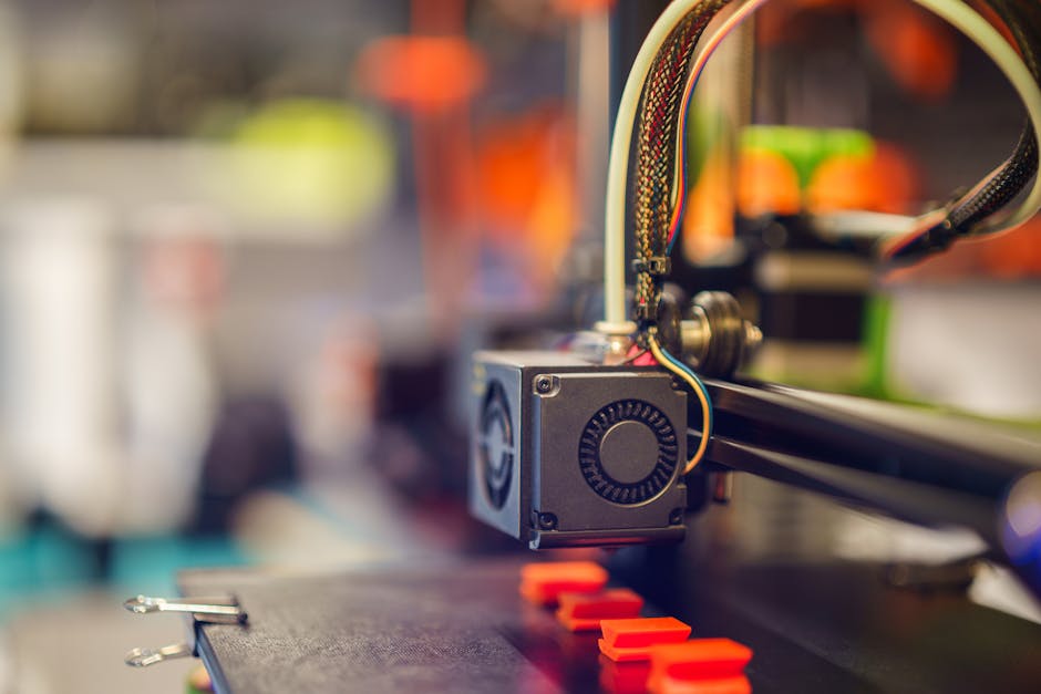 Detailed close-up of a 3D printer extruding red plastic during operation